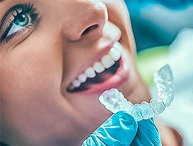 dentist using teeth whitening trays on patient