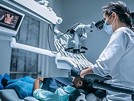 dentist using tools to magnify patients teeth