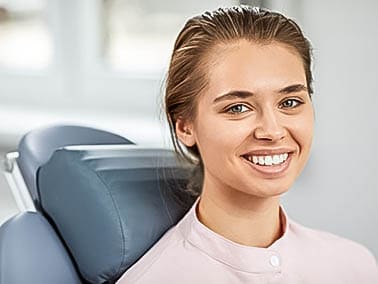 smile makeover patient in pink shirt smiling