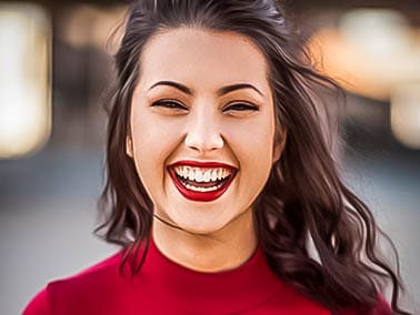 woman in red shirt and red lipstick smiling