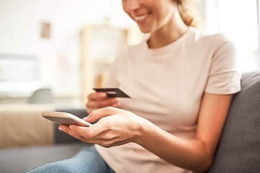 woman using credit card to purchase an item online