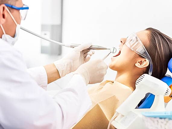woman in protective eye wear receiving a dental procedure
