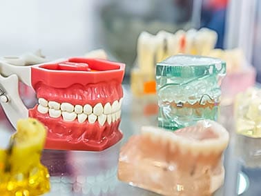 multiple dentures on display on a glass table