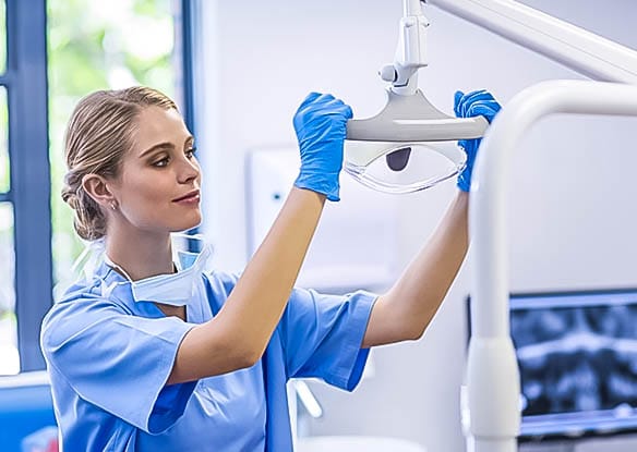 female dental hygienist prepping room for oral surgery