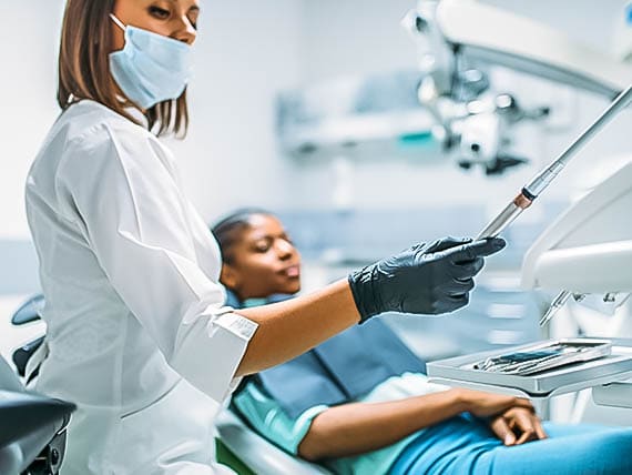 female dentist preparing to give patient a root canal