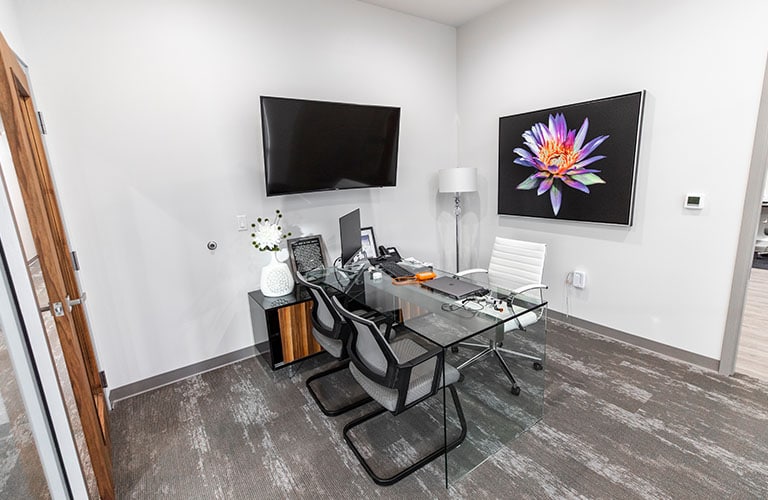 dental consultation office with glass desk and three chairs